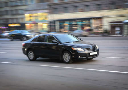 black luxury car moves on the city streetの写真素材