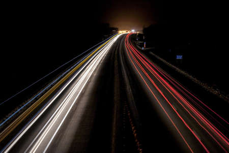 night winter highway with light lines from passing carsの写真素材