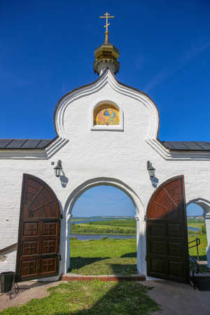 arch of gate of ancient Christian church against landscapeの写真素材