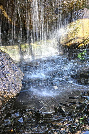 falls in stone grotto shined with sunlightの写真素材