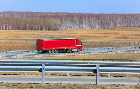 big trailer with red cabin goes on roadの写真素材
