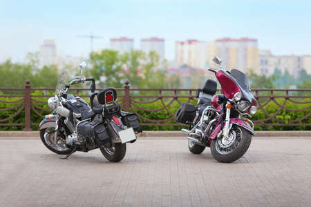 two motorcycles on parking against the city