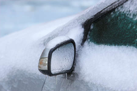 car in winter covered with ice and snowの写真素材