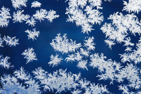 hoarfrost patterns on glass in the winter at nightの写真素材