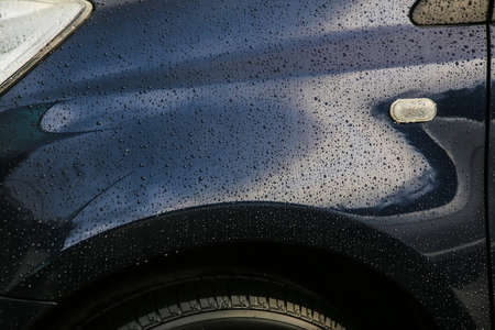 dark blue car in rain drops close upの写真素材