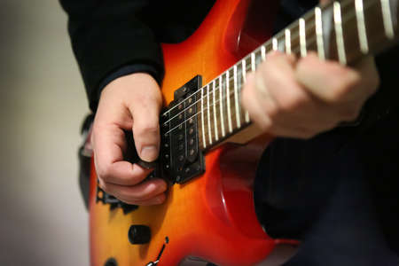 guitarist's fingers on guitar strings close up