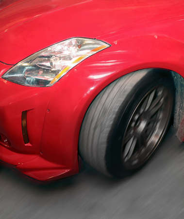 red sports car in movement close upの写真素材