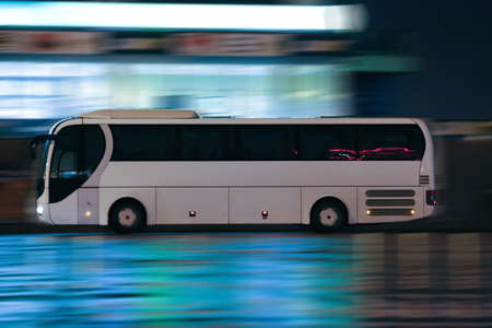 white bus moves on night cityの写真素材