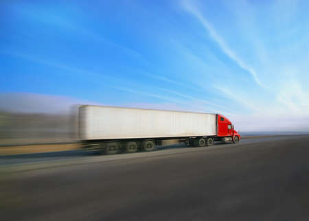 trailer with red awning moves at high speed on the highwayの写真素材