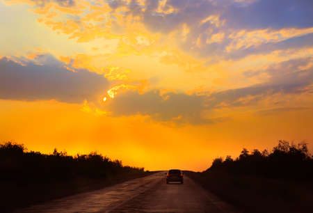 car moves on road towards to sunsetの写真素材