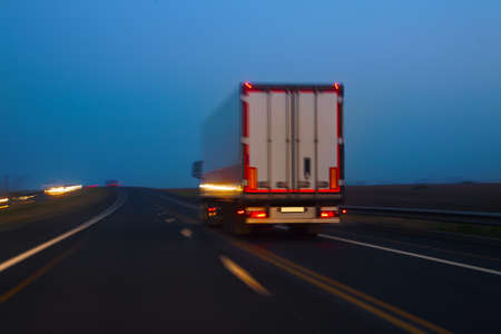 truck moves on country highway at nightの写真素材