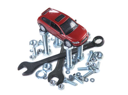 red toy car on wrenches bolts and nutsの写真素材
