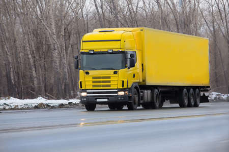 winter yellow truck goes on highway