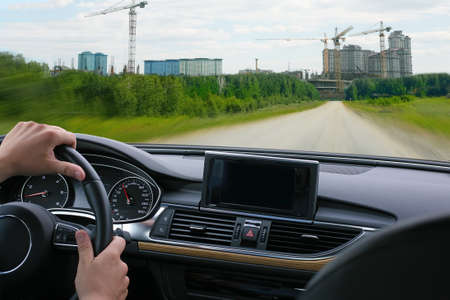 driver in salon car goes to city under constructionの写真素材