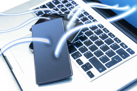 smartphones on laptop keyboard conceptually connectの写真素材