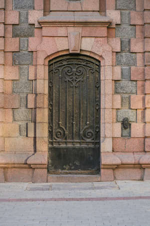 ancient stone wall with metal forged doorの写真素材