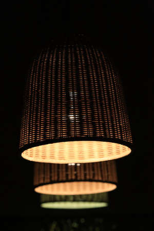 three shining wattled lamp shades in dark roomの写真素材