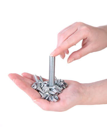 chrome bolts and nuts in female hands isolatedの写真素材