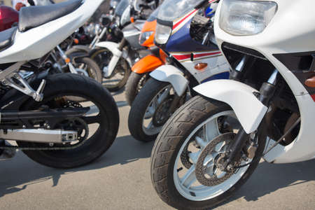 many motorcycles on parking on asphalt  close upの写真素材