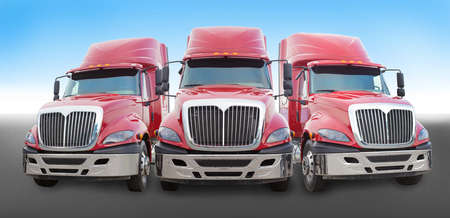 Three large red truck on the roadの写真素材