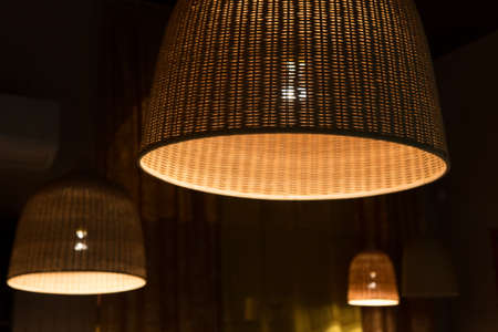three shining wattled lamp shades in dark roomの写真素材