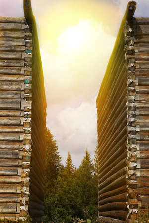 bright sun in the cloudy sky over log housesの写真素材