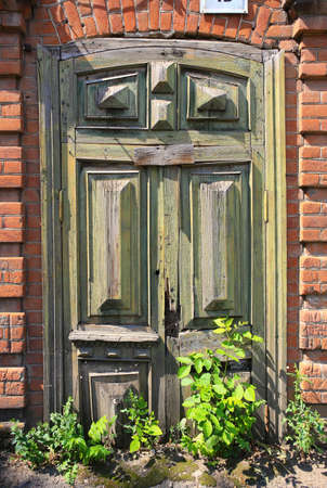 old wooden arch door in an old brick wallの写真素材