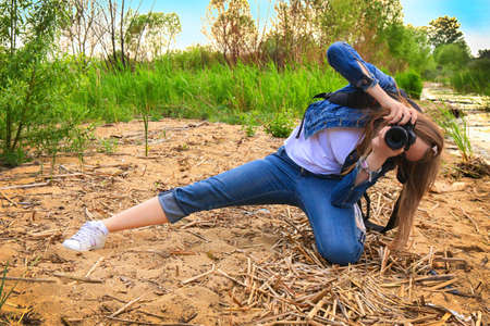 girl photographer on sandy river bank in summerの写真素材