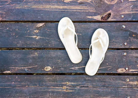 white slippers on dark timber floorの写真素材