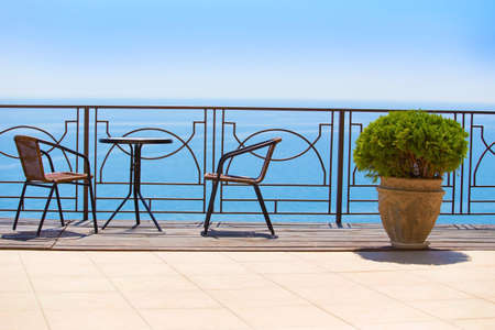 chairs and table on protected terassa by seaの写真素材