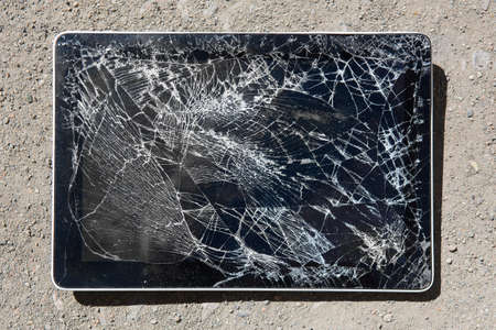 tablet with broken display on roadの写真素材