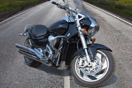 powerful black motorcycle on highway in countryの写真素材