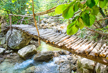small old wooden bridge through streamの写真素材