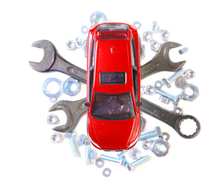 red toy car on wrenches bolts and nutsの写真素材