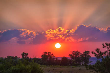 beautiful sunset in cloudy sky over fieldの写真素材