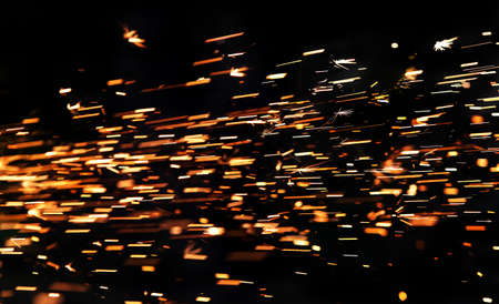 bright sparks of metal against dark backgroundの写真素材