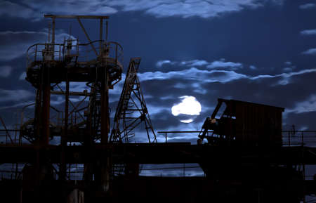 silhouette of old factory in the moonlight nightの写真素材