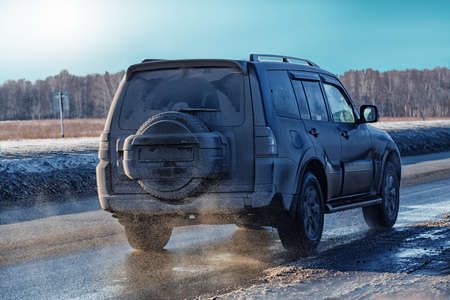 dirty SUV goes in winter on  highwayの写真素材