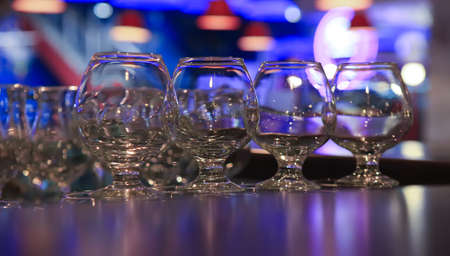 glasses hanging on an arm over bar counter