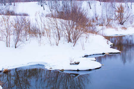 beautiful snow-covered river bank in winterの写真素材