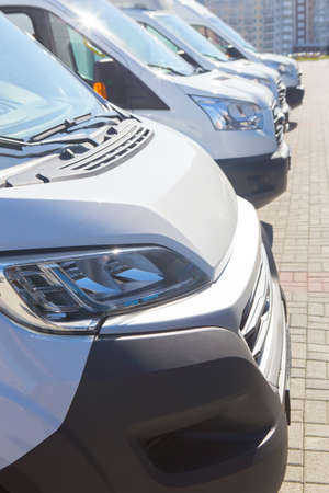 number of new white minibuses and vans outside