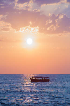 beautiful sunset at sea with vessel at horizonの写真素材