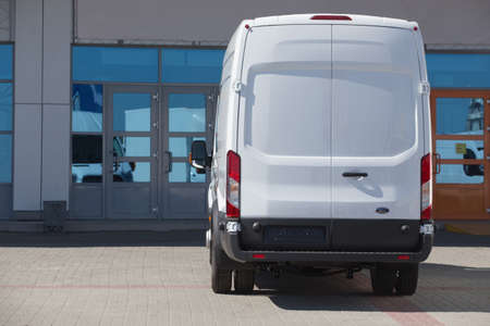 white minibus is parked in city street