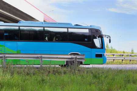 tourist bus goes on highway under bridge in countryの写真素材