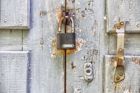 old wooden colored door with padlock and the handleの写真素材
