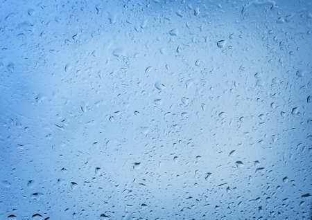 water drops on car windshield reflecting the sky