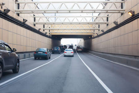 cars leaving tunnel in downtown in sunny dayの写真素材