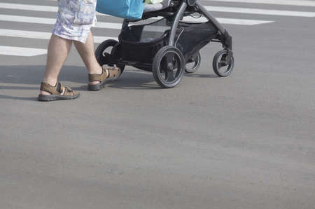 man with baby carriage goes on crosswalk