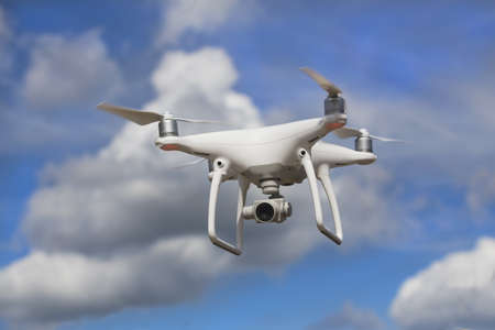 flying quadcopter with camera in blue sky