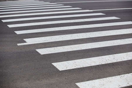 white lines of crosswalk on asphalted road